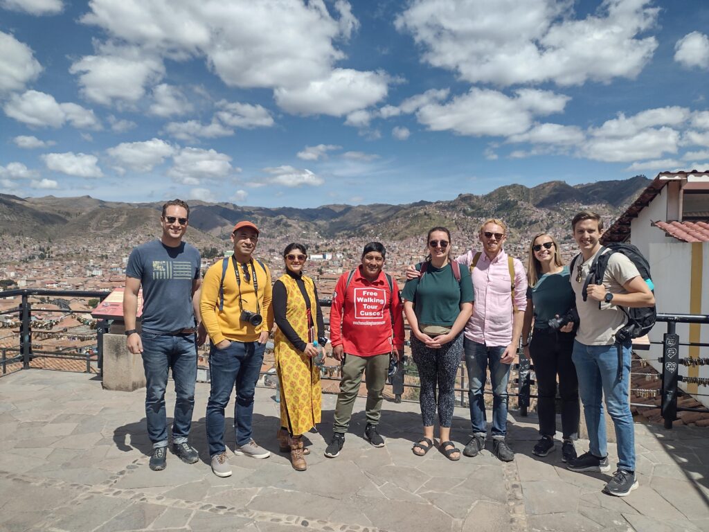 Jose Martinez, lead guide of Free Walking Tour Cusco, with a group of tourists overlooking the panoramic Cusco Valley.