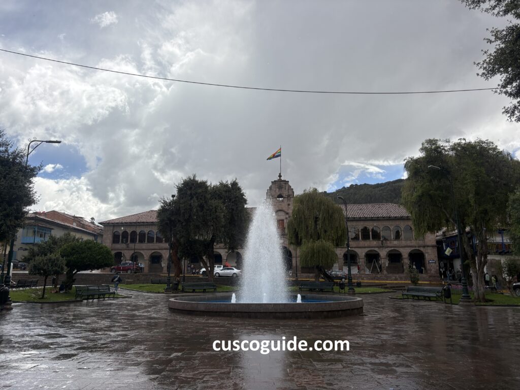 Fountain at Regocijo Square in Cusco, surrounded by colonial buildings and historic architecture.